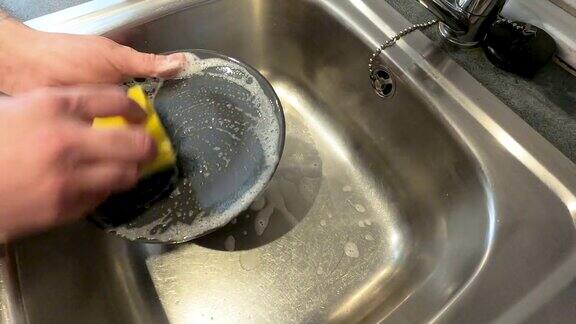 男人的手用洗涤剂洗盘子