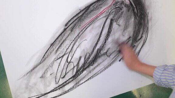 那位艺术家用煤块在帆布上画了一个女人画布放在画架上画画的过程