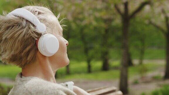 女人在公园里放松和听音乐