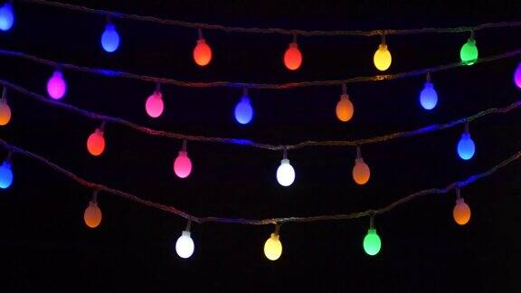 五颜六色的圣诞节日灯串闪烁孤立在黑色背景