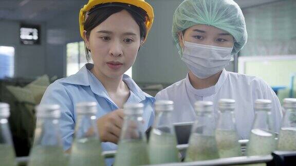 亚洲女主管在饮料加工厂检查药草饮料生产线女工检查瓶中饮料产品流水线加工厂工业理念