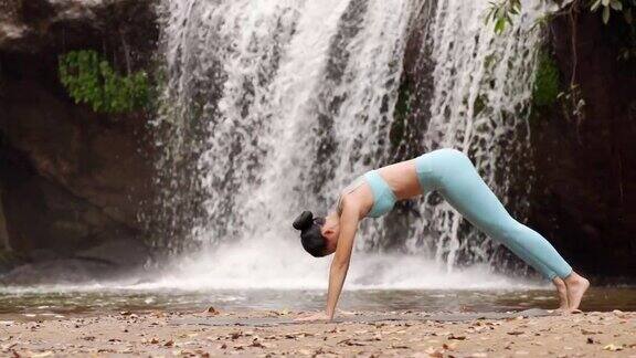 女人在瀑布背景做瑜伽