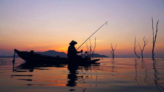 高清慢镜头:泰国日落时分渔民在长尾船上捕鱼