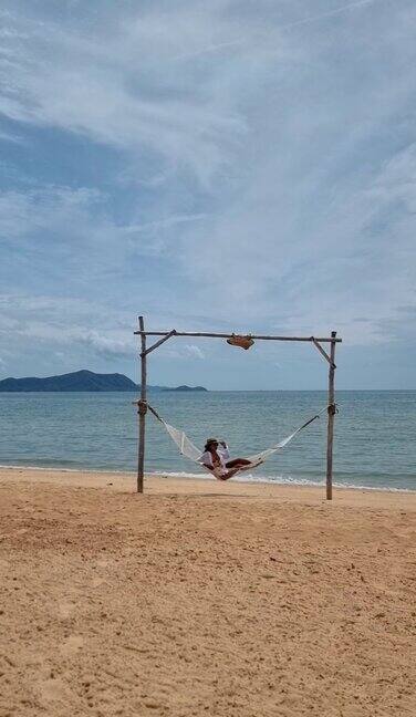 一对男女在泰国芭堤雅的海滩上有吊床和棕榈树