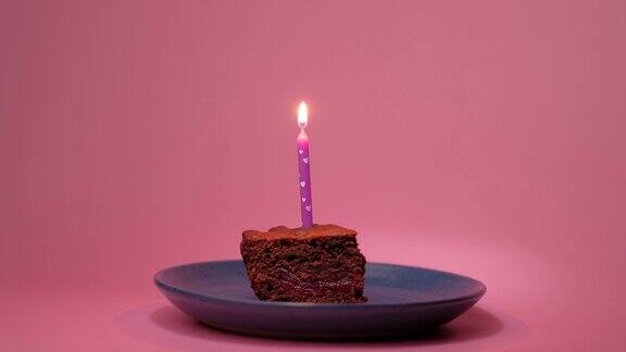 在一块蛋糕上点燃一支蜡烛