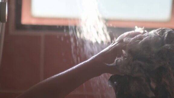 慢镜头早晨开始的一天背光阳光浴室亚洲华人女性洗她的头发与自来水