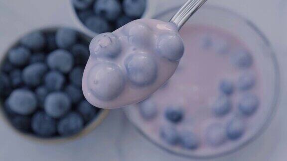 碗里放着酸奶和蓝莓一名女子在吃蓝莓酸奶健康的早餐超级食物健康饮食素食素食