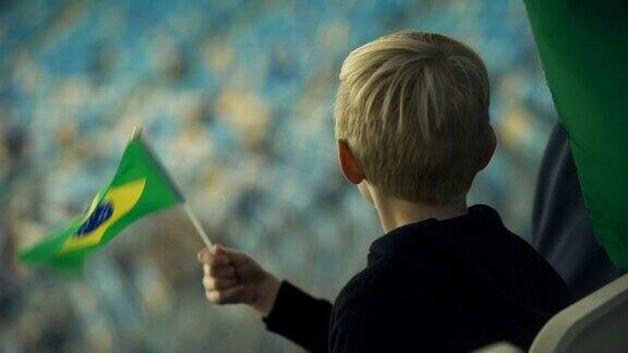 孩子挥舞着巴西国旗为足球队欢呼庆祝胜利
