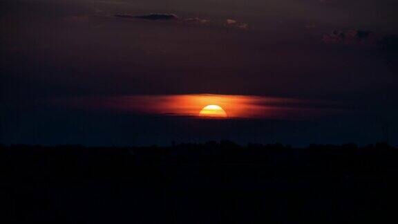 当巨大的太阳沉入地平线时巨大的橙色日落的时间流逝