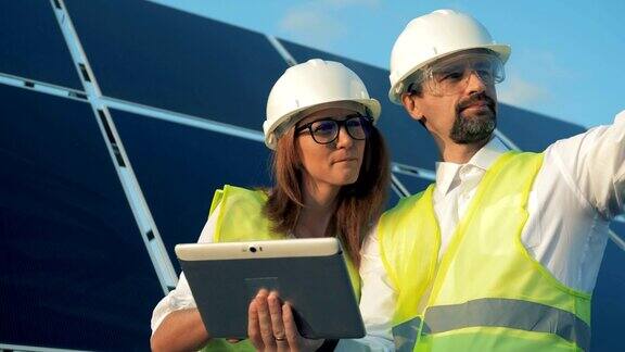 一位女性和一位男性能量工人正在讨论建设项目并指着不同的方向