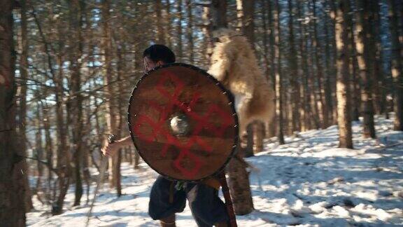 在森林里中世纪的武士拿着盾牌和剑练习战斗技巧