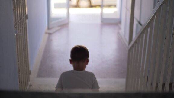 一个孩子独自坐在楼梯上