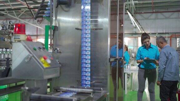 亚洲中国装瓶厂厂长与生产线领班就检查表和饮用水生产进度进行沟通