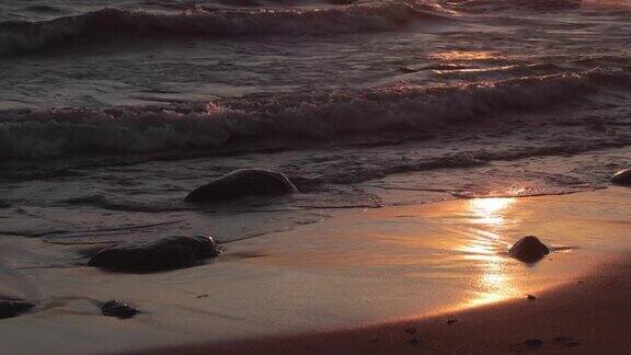 日落时波浪起伏的沙滩