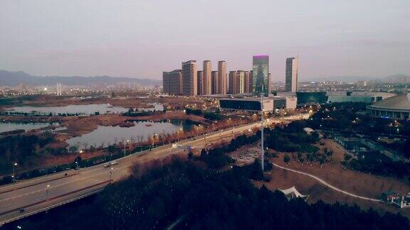 中国义乌日落时分的城市景观鸟瞰图汽车在桥上行驶
