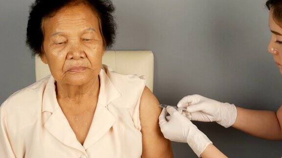 医生在当地医院给病人的手臂注射流感疫苗