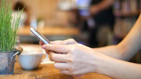 女人用手发短信在咖啡馆用智能手机
