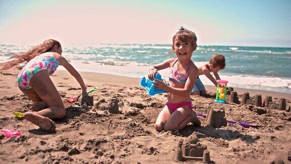 夏天年轻的多民族朋友们在海滩上堆沙堡
