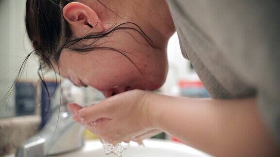 年轻的亚洲妇女洗脸