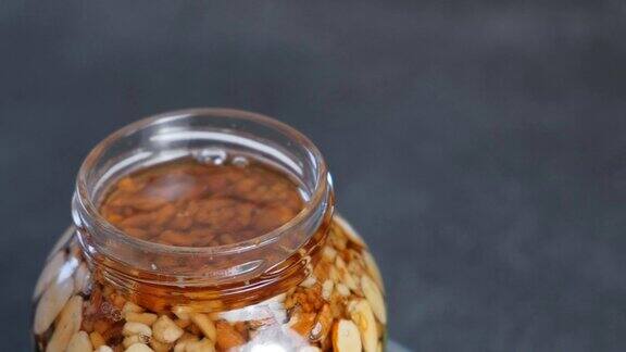 旋转开罐与坚果在蜂蜜特写镜头前视图