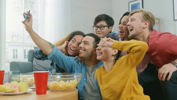 在家里一群不同的朋友一起自拍一个家伙举起手机人们微笑大笑做鸭唇“轰趴”直播的年轻人