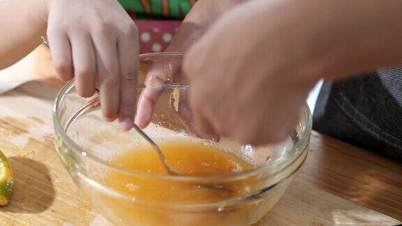 亚洲女孩教她的妹妹如何挤橙汁在家里处理甜果冻
