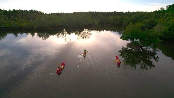 日落场景鸟瞰组游客旅行者或研究人员划桨划艇在淡水河湖发现和探索植物园热带地区的自然攀牙省泰国