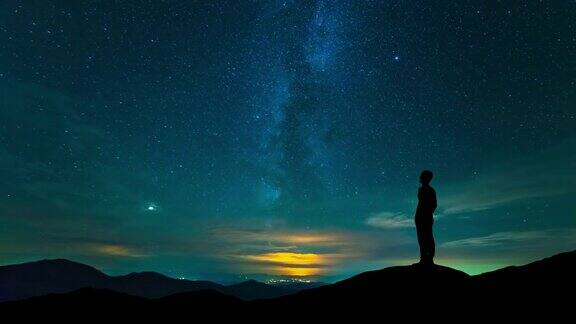 那个人站在山顶上背景是繁星点点的天空时间流逝