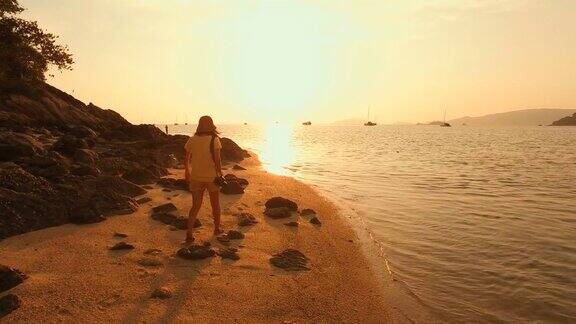 漫步在日落海滩上的年轻女子