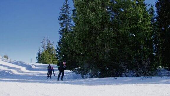 一组四名成年人的慢动作拍摄因为他们在一个阳光明媚的冬天在科罗拉多滑雪在一条线下山