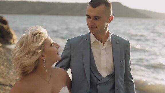 年轻美丽的新婚夫妇一起在海边可爱的新郎和新娘慢动作