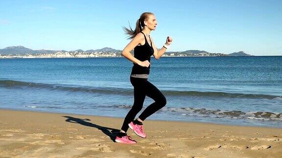 穿着运动服的年轻女孩在海边跑步