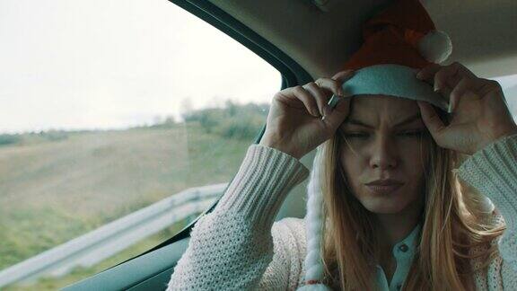 戴着圣诞帽的女人在汽车后座上玩得很开心