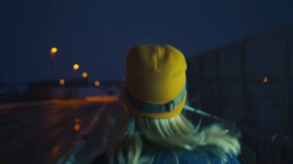 SLOMO女子在夜晚慢跑穿过城市中的一座桥