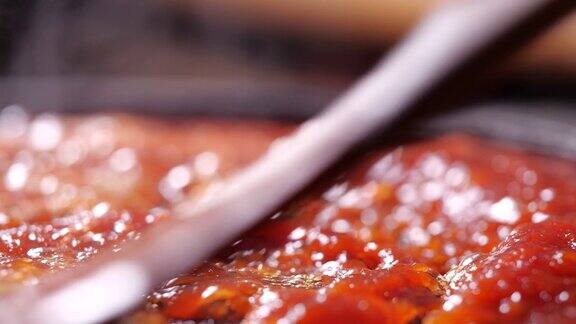 在沸腾的平底锅中煮红番茄酱用4K分辨率用蒸汽搅拌
