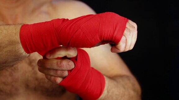 近距离男子拳击手用红色的包裹手腕