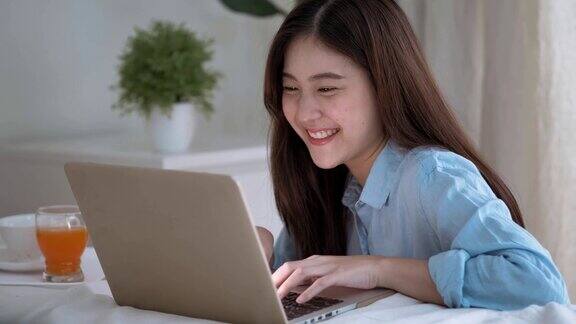 亚洲女性微笑浏览社交媒体在家工作