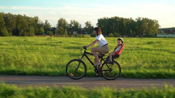 妈妈骑着自行车带着一个小女儿