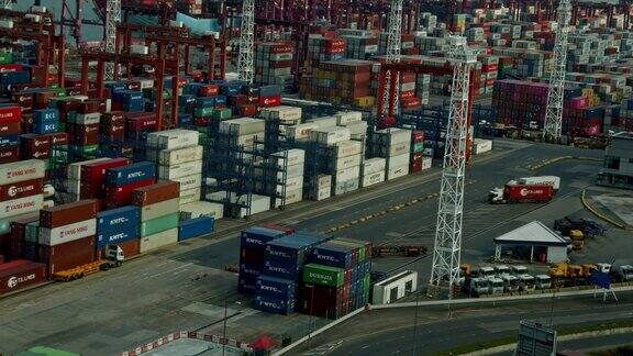 航运业港口与集装箱的4K时间流逝进出口货物国际业务大型起重机在夜间将集装箱卸上卡车
