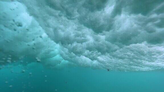 水下:带着冲浪板的惊涛骇浪的海边风景