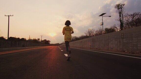 日落时分小女孩在马路上奔跑