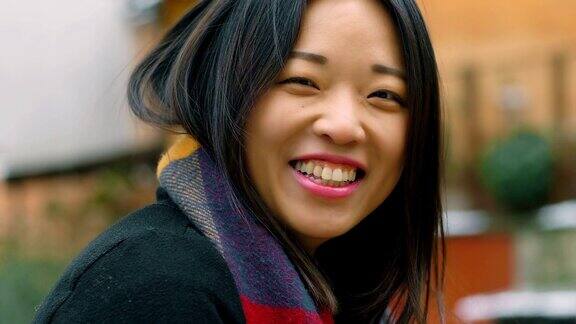 美丽的亚洲女人的肖像在室外笑-慢动作