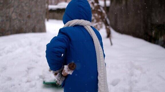 小男孩在冬天铲雪