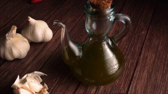 蒜头和丁香红辣椒和橄榄油瓶子在木桌上