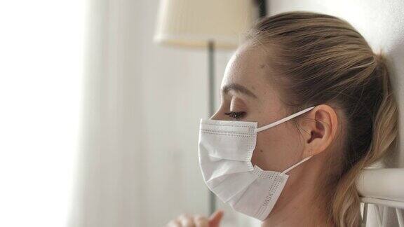 妇女咳嗽戴着口罩躺在家里的床上