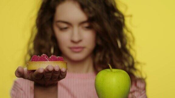 年轻女子选择苹果代替蛋糕减肥营养工作室
