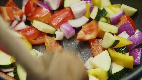 蔬菜沙拉的特写是用勺子在平底锅里炒