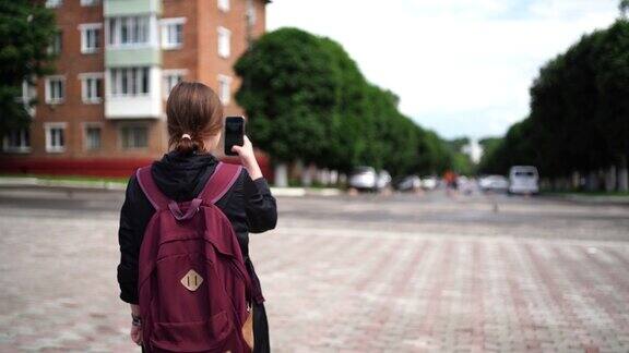 年轻女子用智能手机拍摄城市风景的肖像成年女性游客用手机拍照