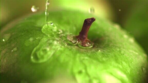 超级慢动作在绿苹果滴水与飞溅用高速摄像机以每秒1000帧的速度拍摄