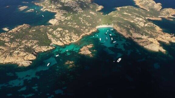 从上往下看莫托里奥岛令人惊叹的鸟瞰图美丽的白色沙滩和一些船和游艇漂浮在蓝绿色水晶般清澈的水面上意大利撒丁岛